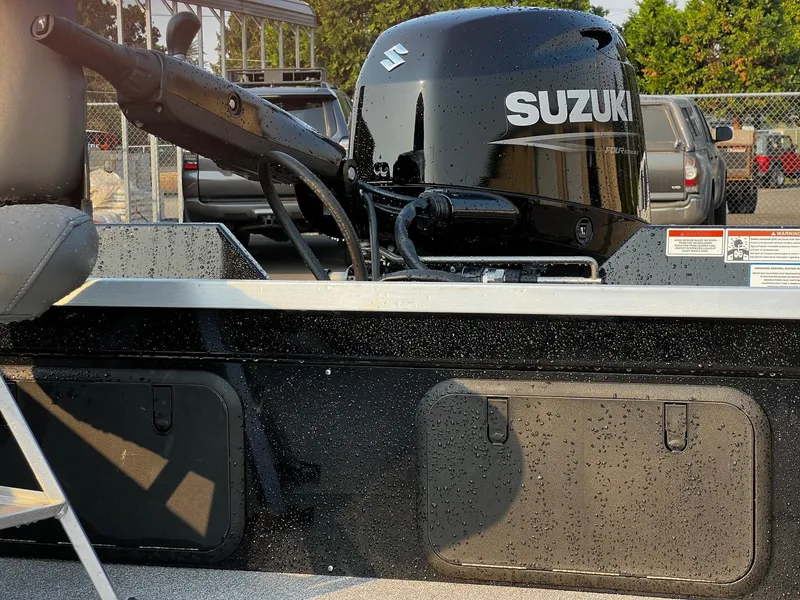 Slide: The Image of 2025 Fish Rite Angler 18 boat with Suzuki outboard motor, parked outdoors. - 11