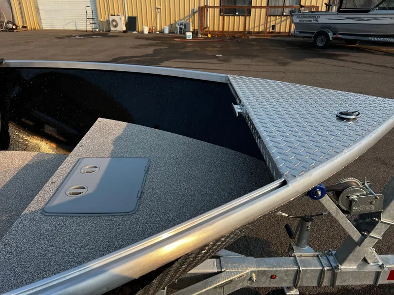 Slide: The Image of 2025 Fish Rite Angler 18 boat on trailer, featuring diamond plate deck. - 14