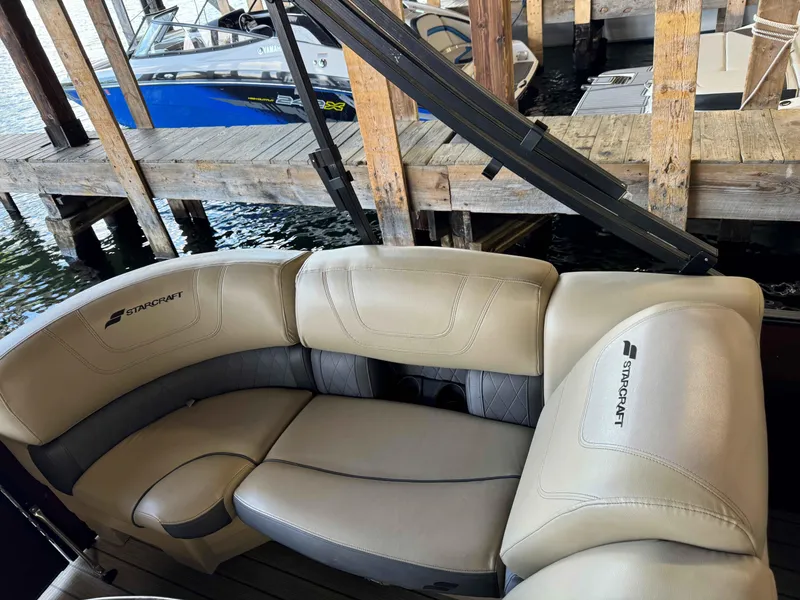 Slide: The Image of Starcraft SLS 3 boat interior with beige seating, docked near wooden pier. - 5