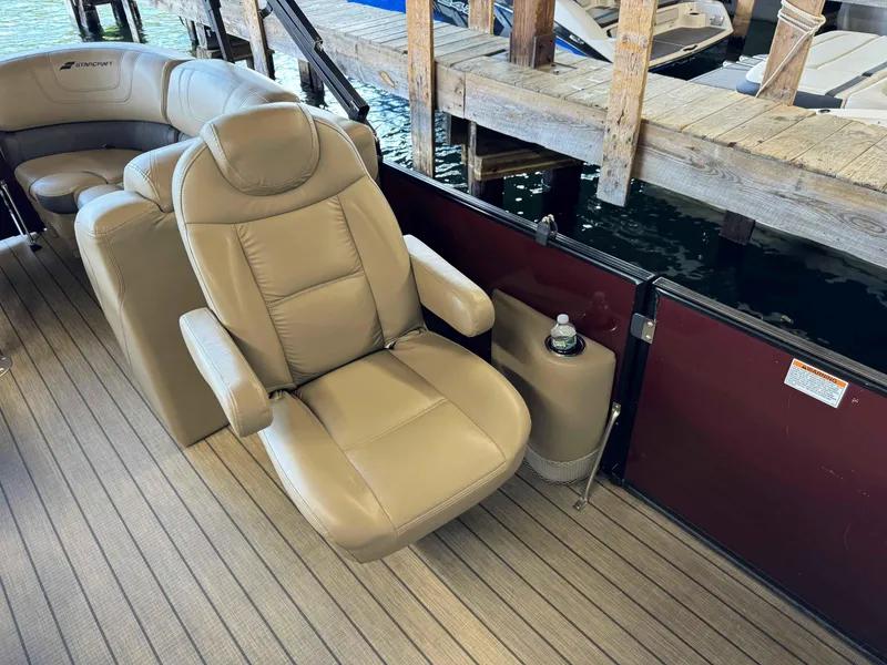 Slide: The Image of 2019 Starcraft SLS 3 boat interior with beige leather seating and wooden dock background. - 6