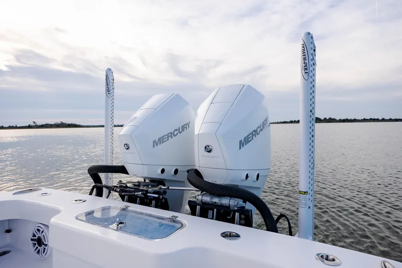 Slide: The Image of Twin Mercury engines on a 2021 ZCB 26 Freemason boat, calm water backdrop. - 12