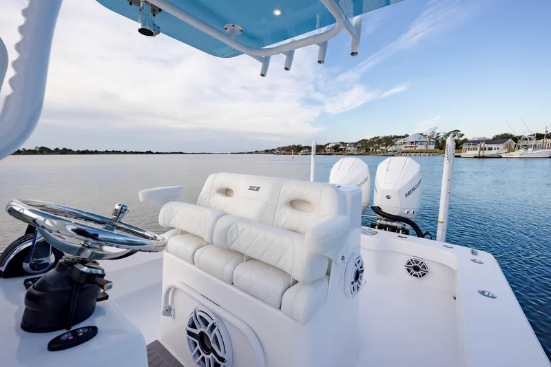 Slide: The Image of 2021 ZCB 26 Freemason boat interior with white seating and dual engines on a calm waterway. - 16
