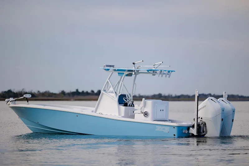 Slide: The Image of 2021 ZCB 26 Freemason boat on calm water, featuring dual outboard motors. - 2