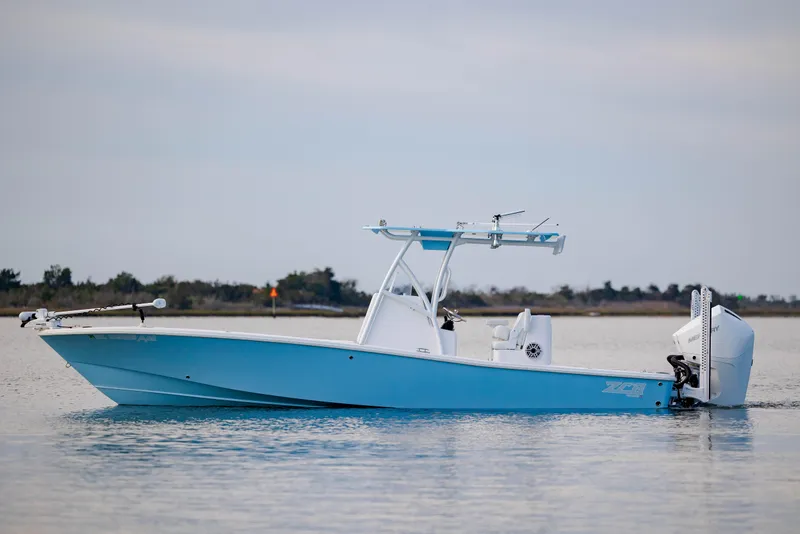 Slide: The Image of ZCB 26 Freemason 2021 boat on calm water, light blue hull, clear sky background. - 3