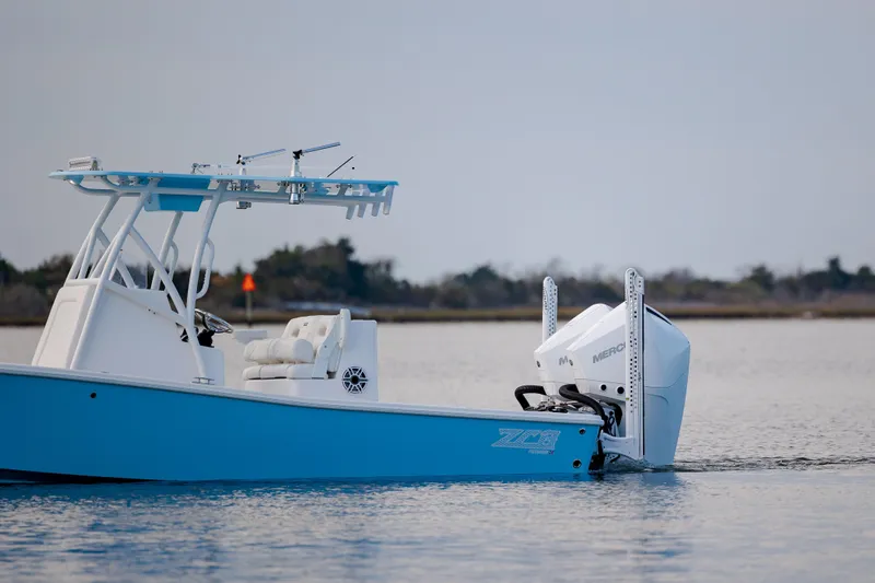 Slide: The Image of Blue 2021 ZCB 26 Freemason boat on calm water with outboard motor. - 4