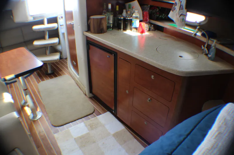 Slide: The Image of 2007 Rinker 350 Express Cruiser interior with kitchenette and seating area. - 10