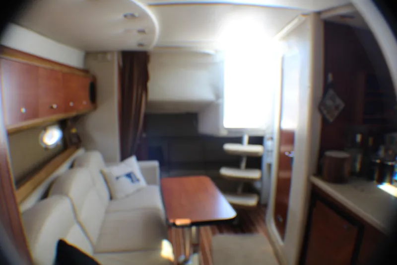 Slide: The Image of Interior of 2007 Rinker 350 Express Cruiser with cozy seating and wooden accents. - 12