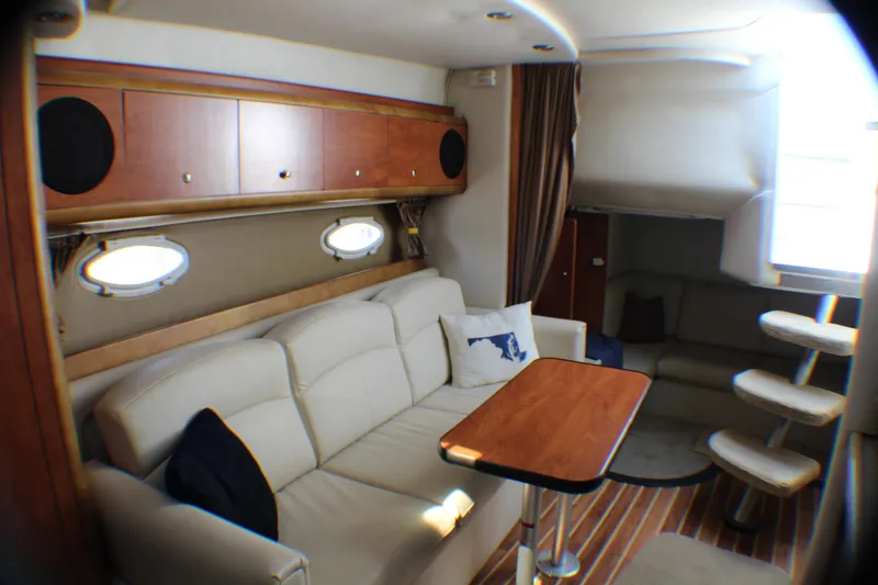 Slide: The Image of Interior of 2007 Rinker 350 Express Cruiser with cozy seating and wooden accents. - 13