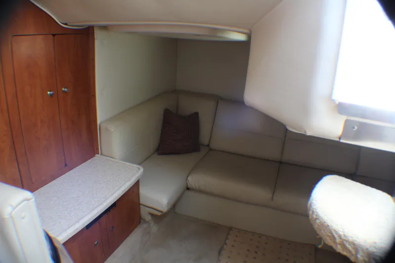 Slide: The Image of 2007 Rinker 350 Express Cruiser interior with beige seating and wooden cabinetry. - 15