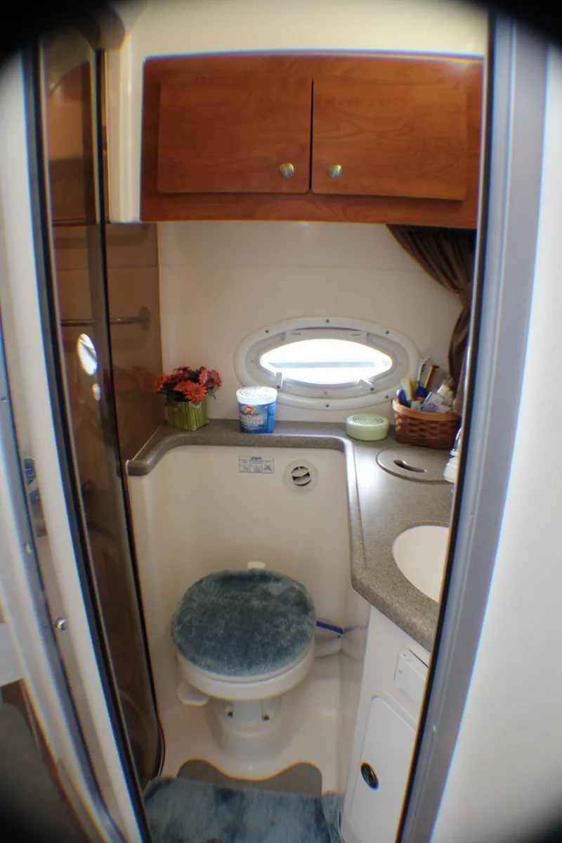 Slide: The Image of 2007 Rinker 350 Express Cruiser bathroom with wooden cabinets and porthole window. - 17