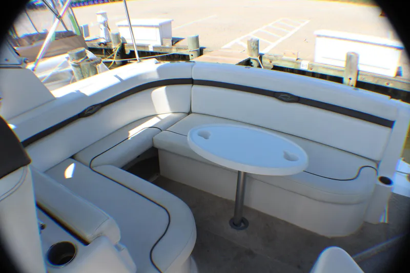 Slide: The Image of 2007 Rinker 350 Express Cruiser interior with white seating and oval table. - 3
