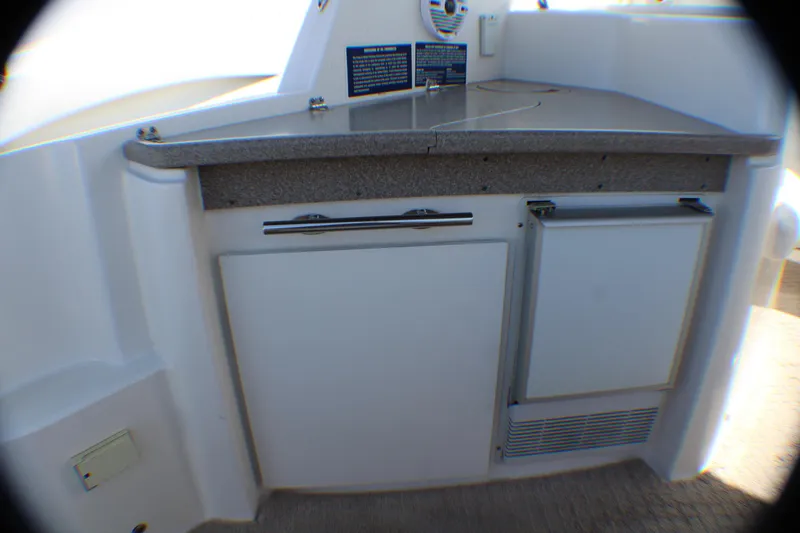 Slide: The Image of 2007 Rinker 350 Express Cruiser kitchenette with countertop and storage cabinets. - 6