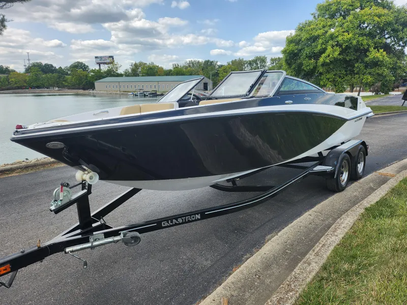 Slide: The Image of 2016 Glastron GT 205 boat on trailer by a lakeside road. - 9