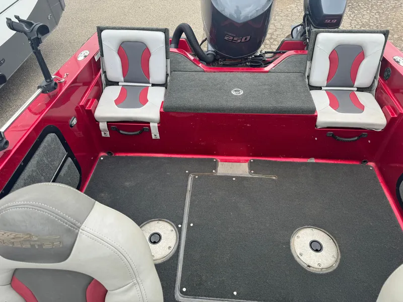 Slide: The Image of 2014 Skeeter WX 2060 boat interior with red and gray seating and carpeted flooring. - 10