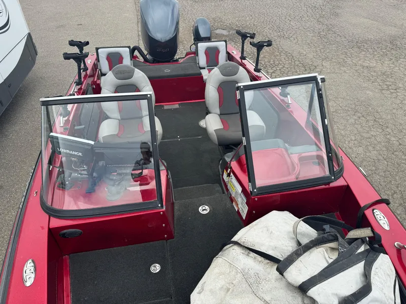 Slide: The Image of 2014 Skeeter WX 2060 boat with dual windshields and seating, parked on pavement. - 17