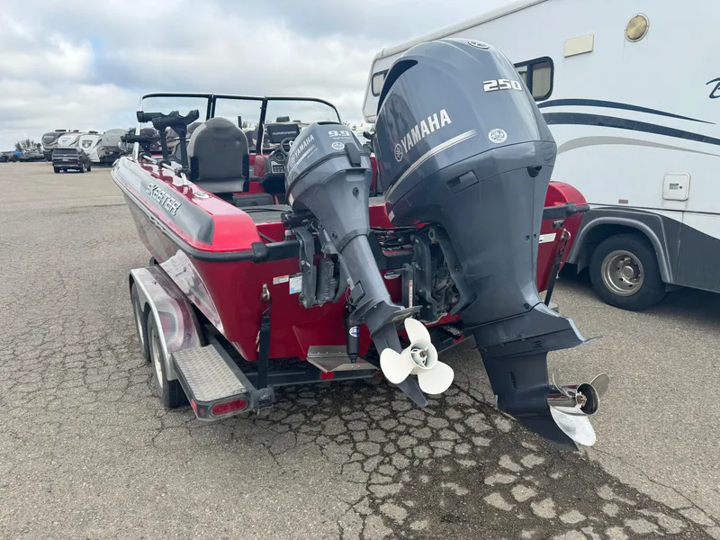 Slide: The Image of 2014 Skeeter WX 2060 boat with dual Yamaha outboard motors in a parking lot. - 4