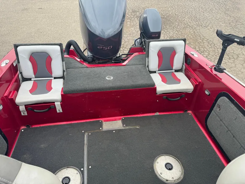 Slide: The Image of 2014 Skeeter WX 2060 boat interior with red and gray seating, outboard motor visible. - 9