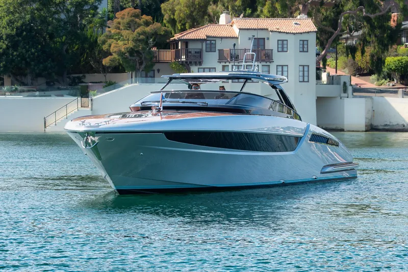 Slide: The Image of 2024 Riva 48 Dolceriva luxury yacht cruising near waterfront homes. - 10
