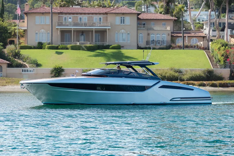 Slide: The Image of 2024 Riva 48 Dolceriva yacht cruising near luxury waterfront homes. - 11