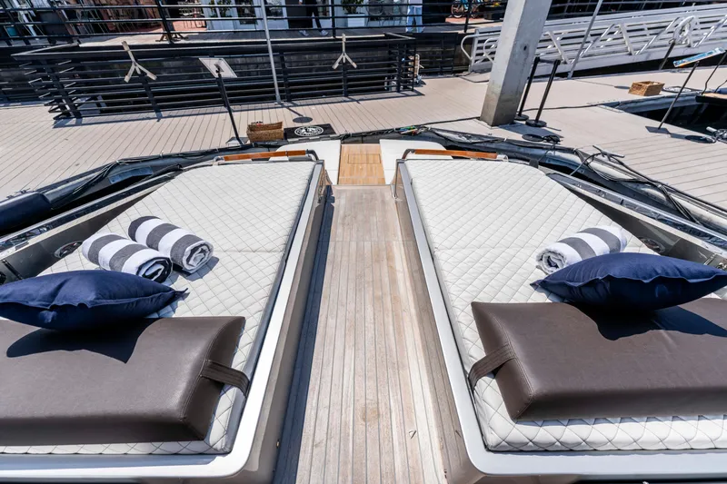 Slide: The Image of 2024 Riva 48 Dolceriva yacht with luxurious sunbeds and striped towels on deck. - 20
