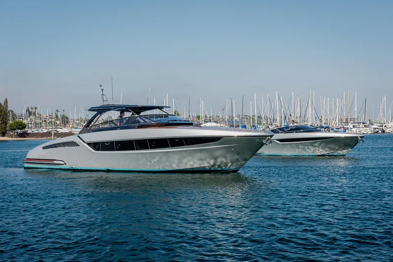 Slide: The Image of 2024 Riva 48 Dolceriva yachts cruising in a marina with sailboats in the background. - 5
