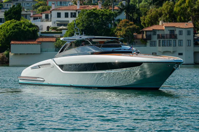 Slide: The Image of 2024 Riva 48 Dolceriva yacht cruising on a serene waterfront. - 7