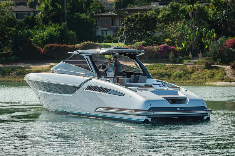 Slide: The Image of 2024 Riva 48 Dolceriva luxury yacht cruising on a serene waterway. - 9