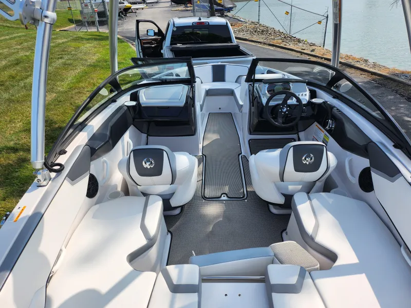 Slide: The Image of 2017 Scarab 195 boat interior with modern seating and dashboard, docked by a lake. - 10