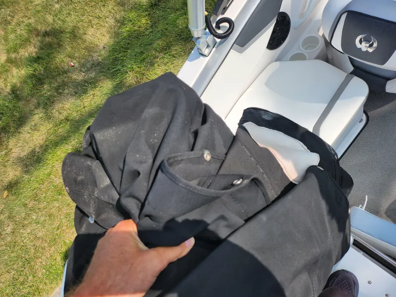 Slide: The Image of Person holding black fabric on a 2017 Scarab 195 boat. - 11