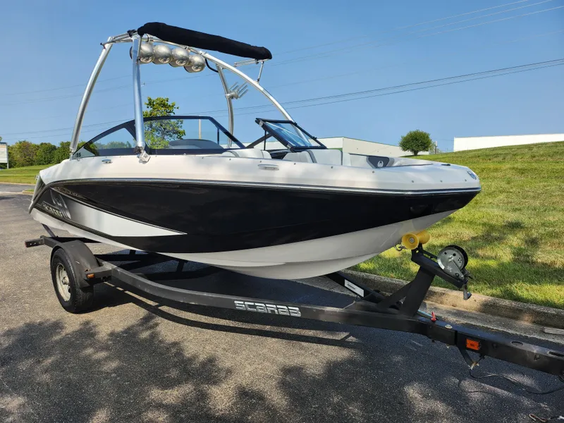 Slide: The Image of 2017 Scarab 195 boat on trailer, black and white design, parked outdoors. - 5