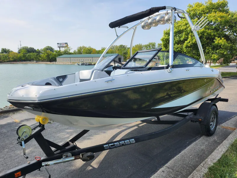 Slide: The Image of 2017 Scarab 195 boat on trailer by a lake, ready for water adventure. - 8