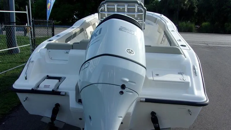 Slide: The Image of 2025 Key West 239 FS boat with powerful outboard motor, parked on pavement. - 18