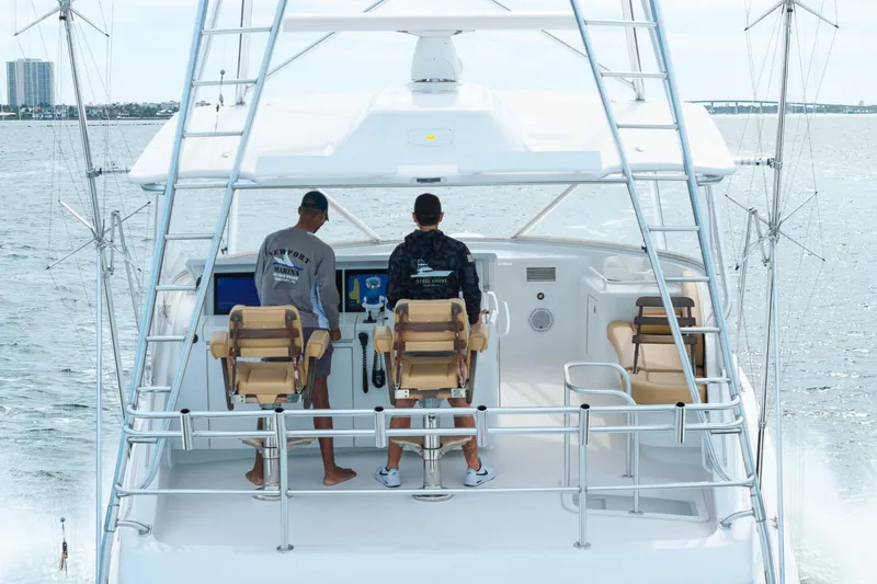 Slide: The Image of Two people steering a 2010 Hatteras GT60 yacht on open water. - 14