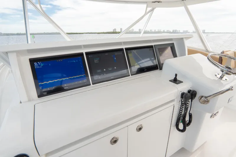 Slide: The Image of 2010 Hatteras GT60 helm with modern navigation displays and controls. - 16