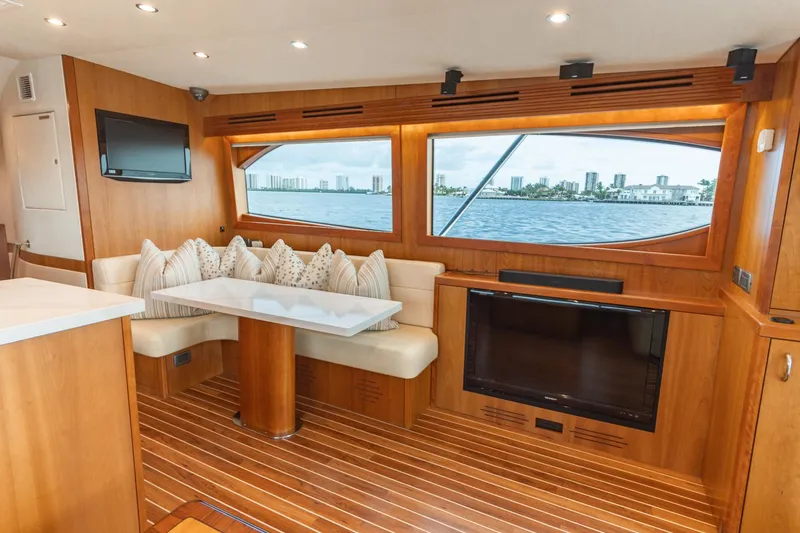 Slide: The Image of Luxurious 2010 Hatteras GT60 yacht interior with wood finish, seating, and waterfront view. - 38