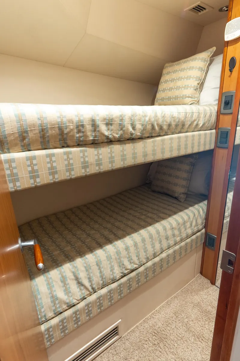 Slide: The Image of Bunk beds in 2010 Hatteras GT60 yacht cabin, featuring patterned bedding. - 45
