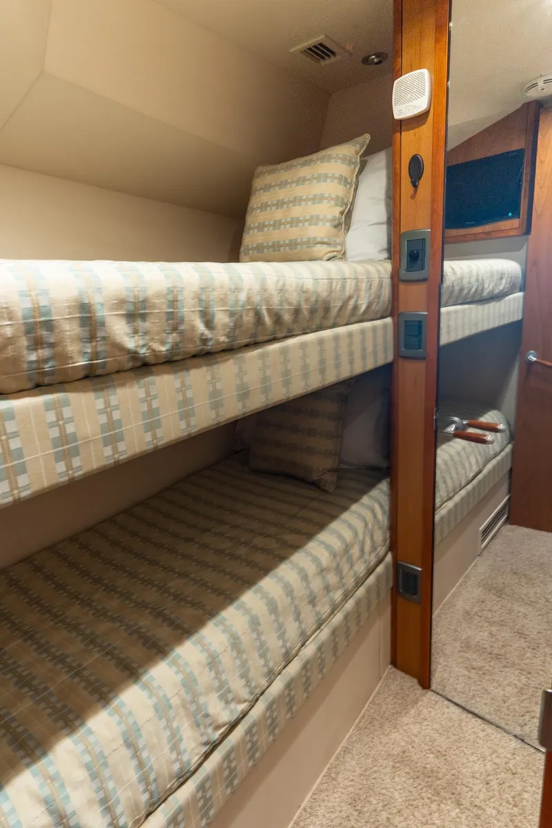 Slide: The Image of Bunk beds in 2010 Hatteras GT60 yacht cabin with patterned bedding. - 46