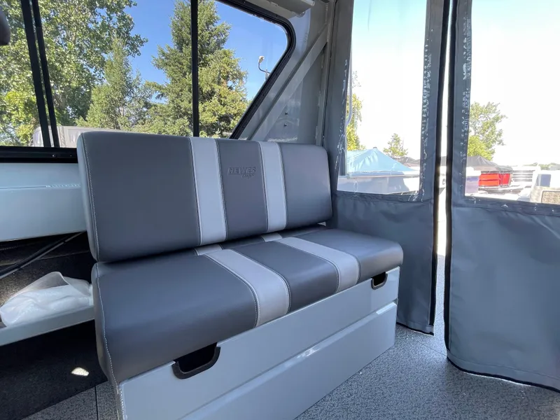Slide: The Image of 2025 Hewescraft 210 Sea Runner ET HT interior with gray seating and large windows. - 11