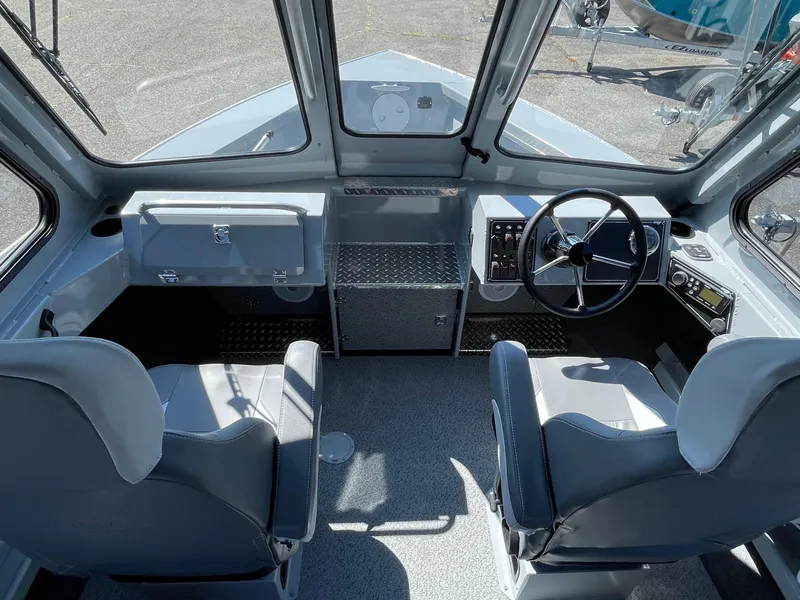 Slide: The Image of Interior of 2025 Hewescraft 210 Sea Runner ET HT boat, featuring dual seats and steering console. - 12