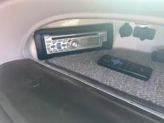 Slide: The Image of 2007 Chaparral 220 SSi boat stereo system with remote control on carpeted surface. - 14