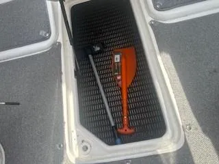 Slide: The Image of Storage compartment in a 2007 Chaparral 220 SSi boat with paddle and pole. - 17