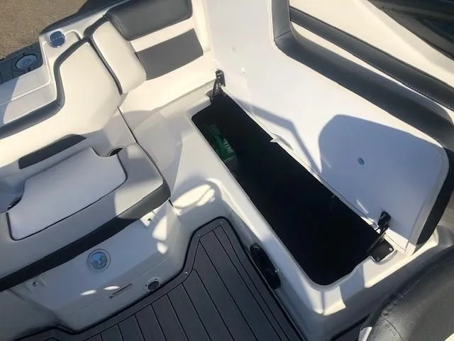 Slide: The Image of 2025 Yamaha Boats 195S interior with open storage compartment and sleek seating design. - 17