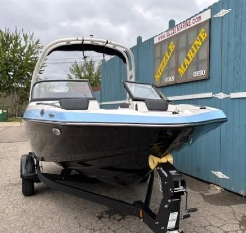 Slide: The Image of 2025 Yamaha Boats 195S on trailer at dealership, blue and black design. - 2