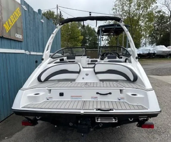 Slide: The Image of 2025 Yamaha Boats 195S, white, rear view, parked outdoors near a blue fence. - 4