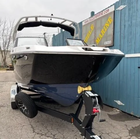 Slide: The Image of 2025 Yamaha Boats 222S on trailer, parked near blue fence. - 2