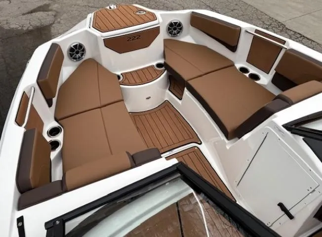Slide: The Image of 2025 Yamaha Boats 222S interior with brown seating and wood accents. - 7