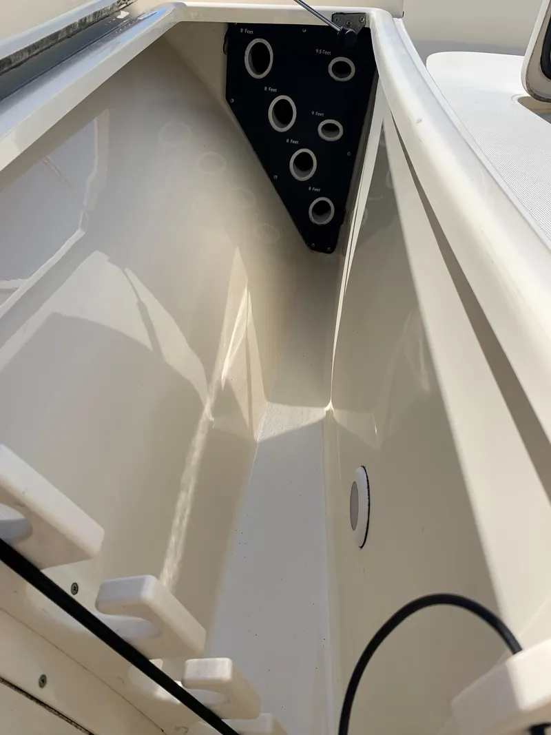Slide: The Image of 2008 Scout 221 Winyah Bay boat interior with rod holders and storage compartment. - 14