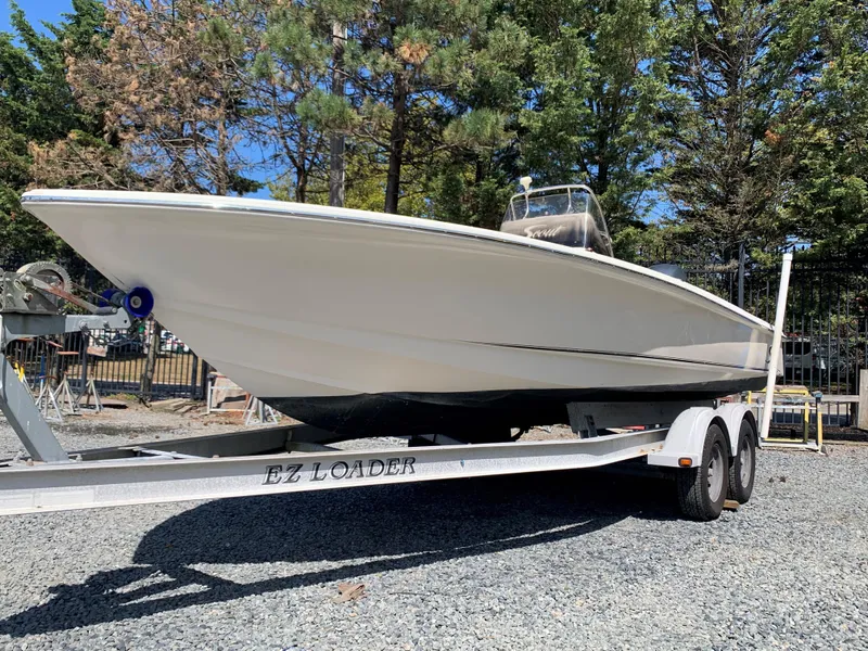Slide: The Image of 2008 Scout 221 Winyah Bay boat on EZ Loader trailer, surrounded by trees. - 3