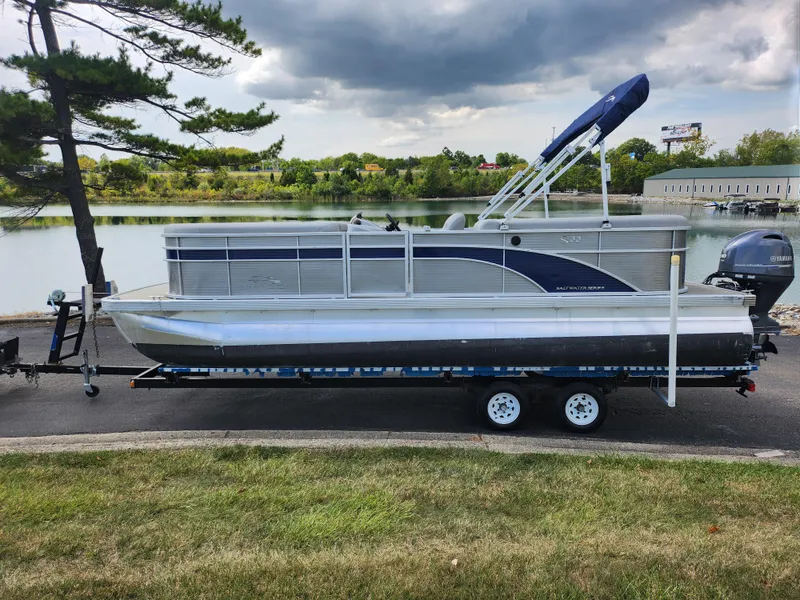 Slide: The Image of 2022 Bennington S 22 SSR pontoon boat on trailer by a scenic lake. - 10
