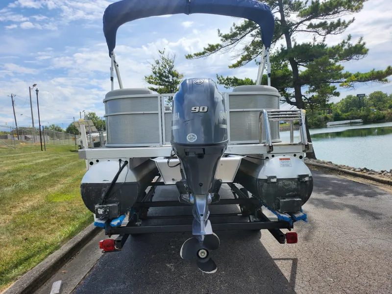 Slide: The Image of 2022 Bennington S 22 SSR pontoon boat with 90 HP engine, parked near a lake. - 3